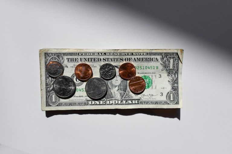 A dollar bill with coins on it.